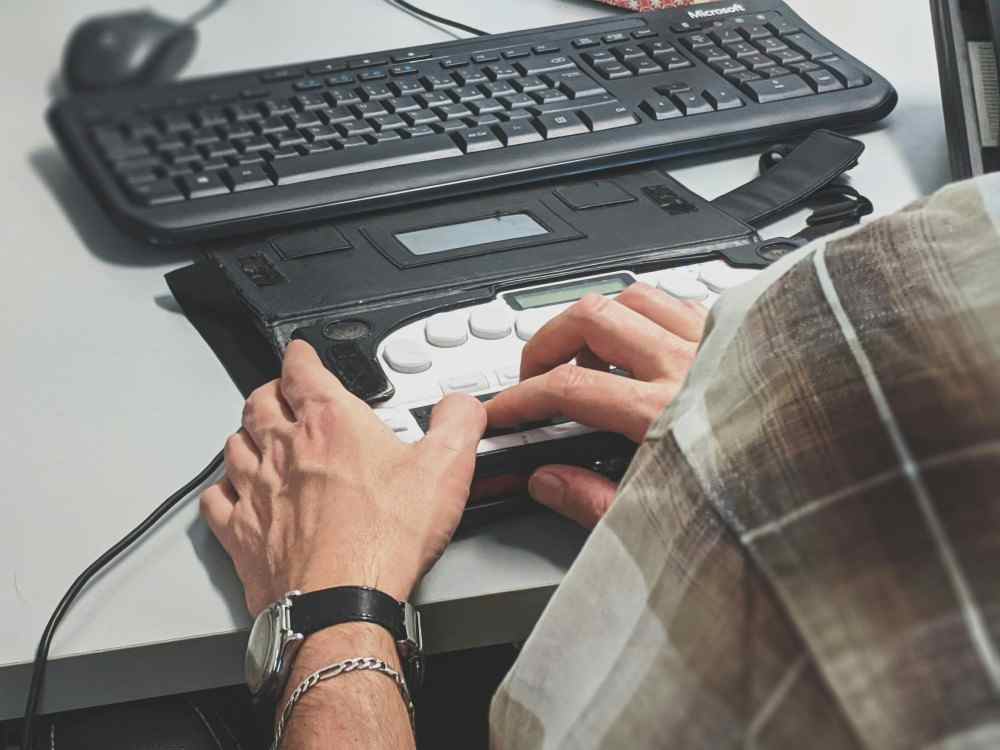 Homme travaillant sur un clavier spécial pour personne en situation de handicap