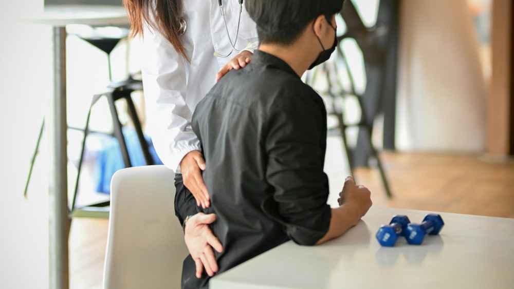 Homme se faisant manipuler, car douleur bas du dos gauche
