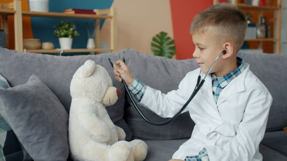 Petit garçon jouant au docteur avec son nounours