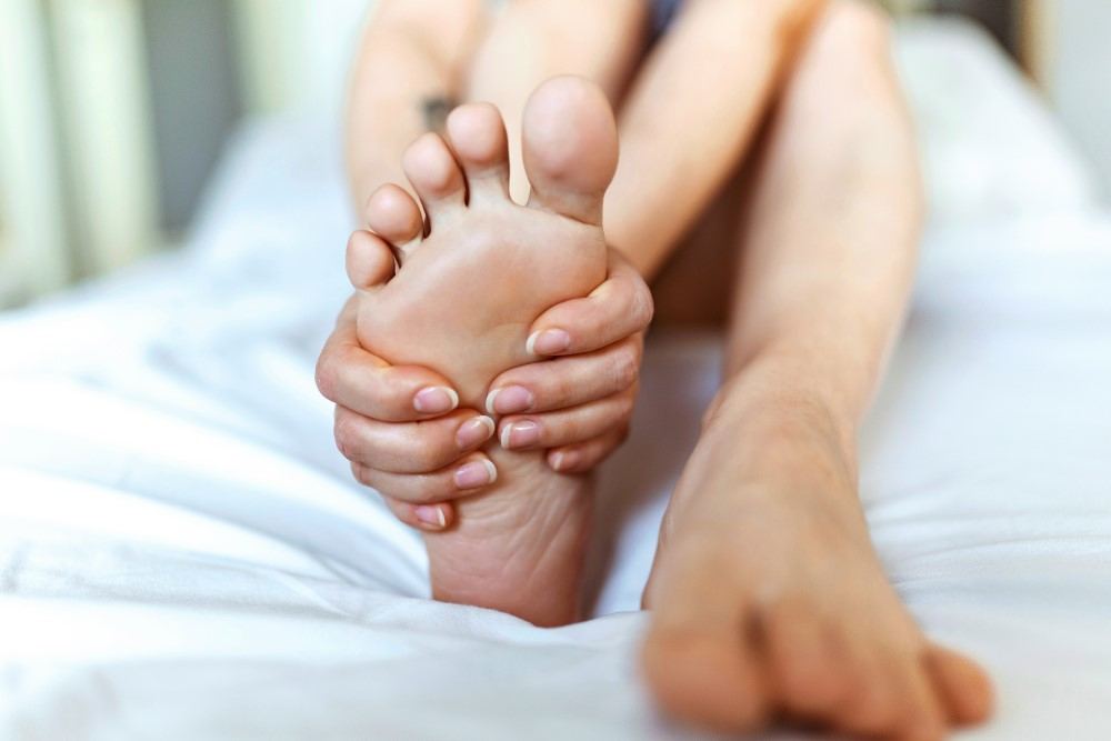 Présentation d'une femme se tenant le pied douleurs