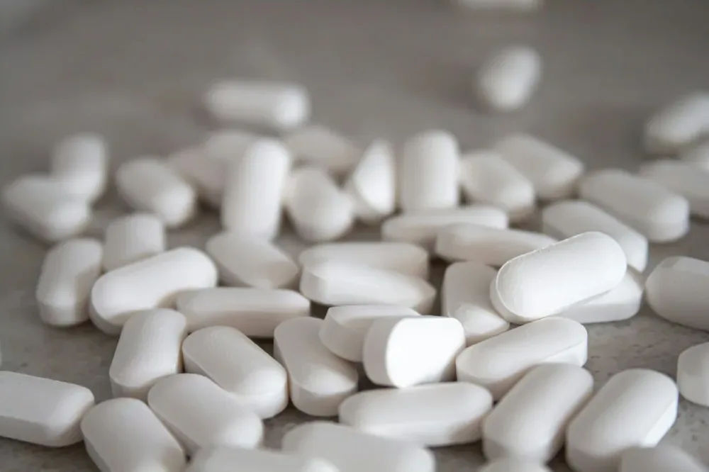Lyrica : des gélules blanches posées sur une surface brune, évocation sobre d’un médicament.